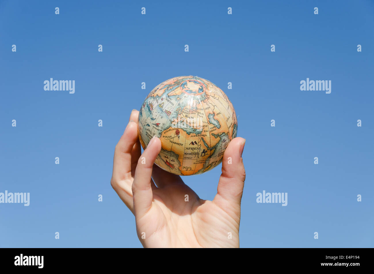 stilisierte globale Erde Miniatur in der Hand auf blauen Himmelshintergrund, Umwelt-Bedienkonzept Stockfoto