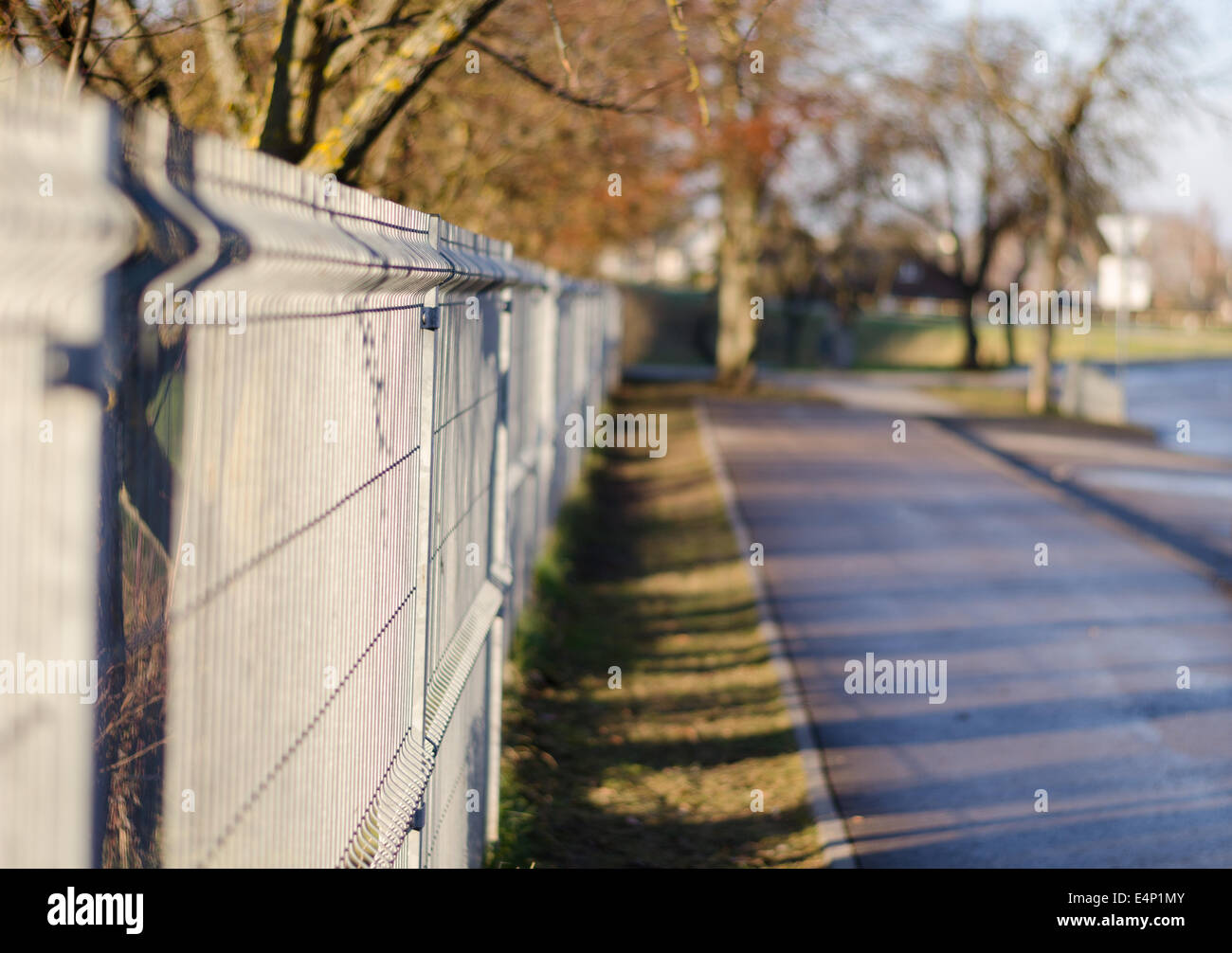 Eisenzaun Stangen lange auf dem asphaltierten Weg Stockfoto