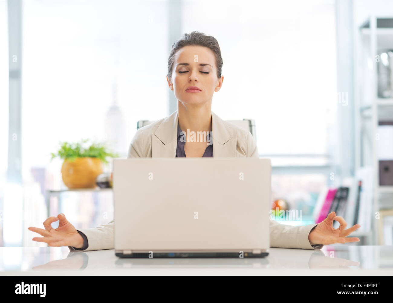 Business-Frau in der Nähe von Laptop zu meditieren Stockfoto
