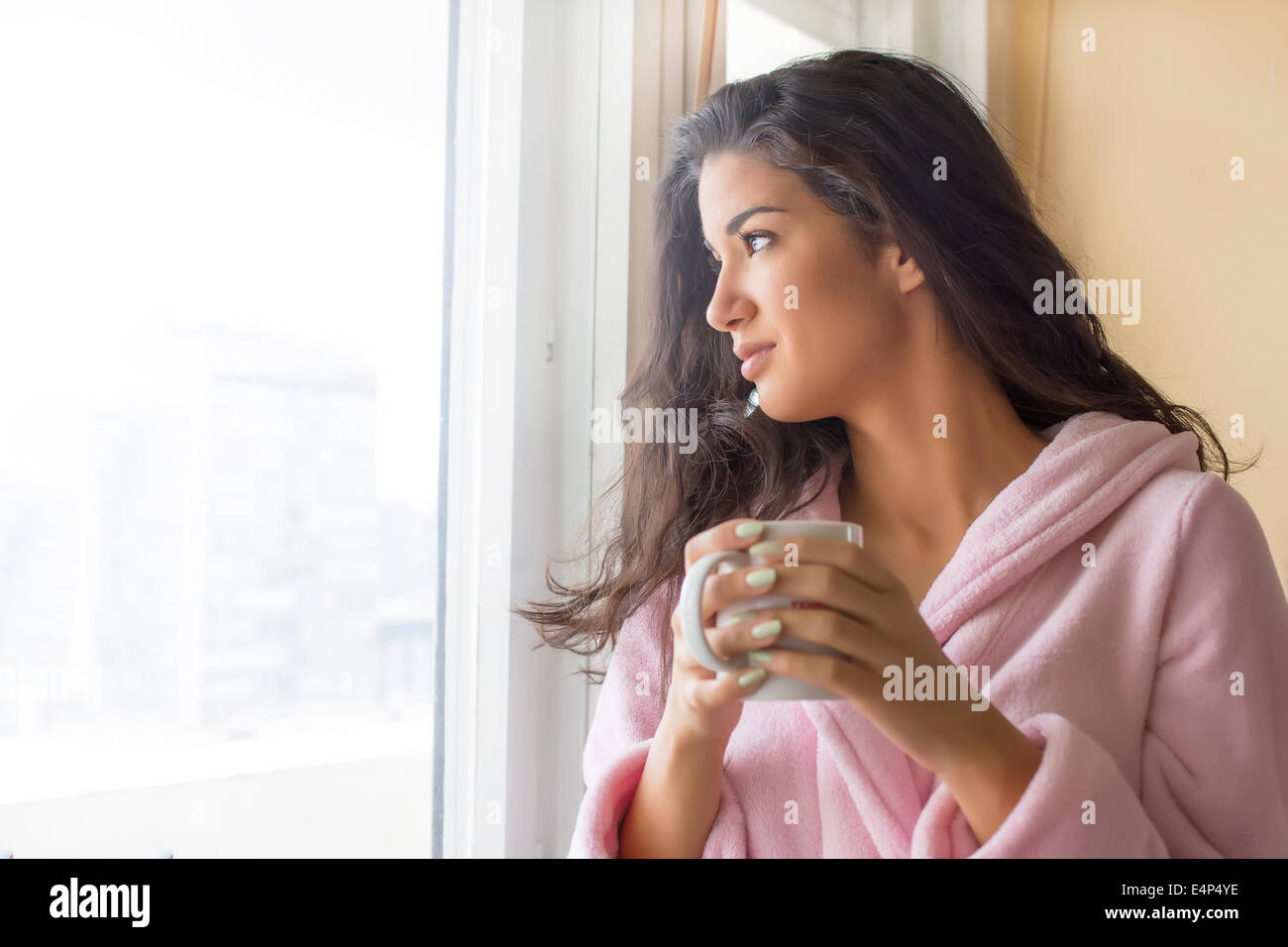 Junge Frau mit Kaffee am Morgen auf der Terrasse Stockfoto