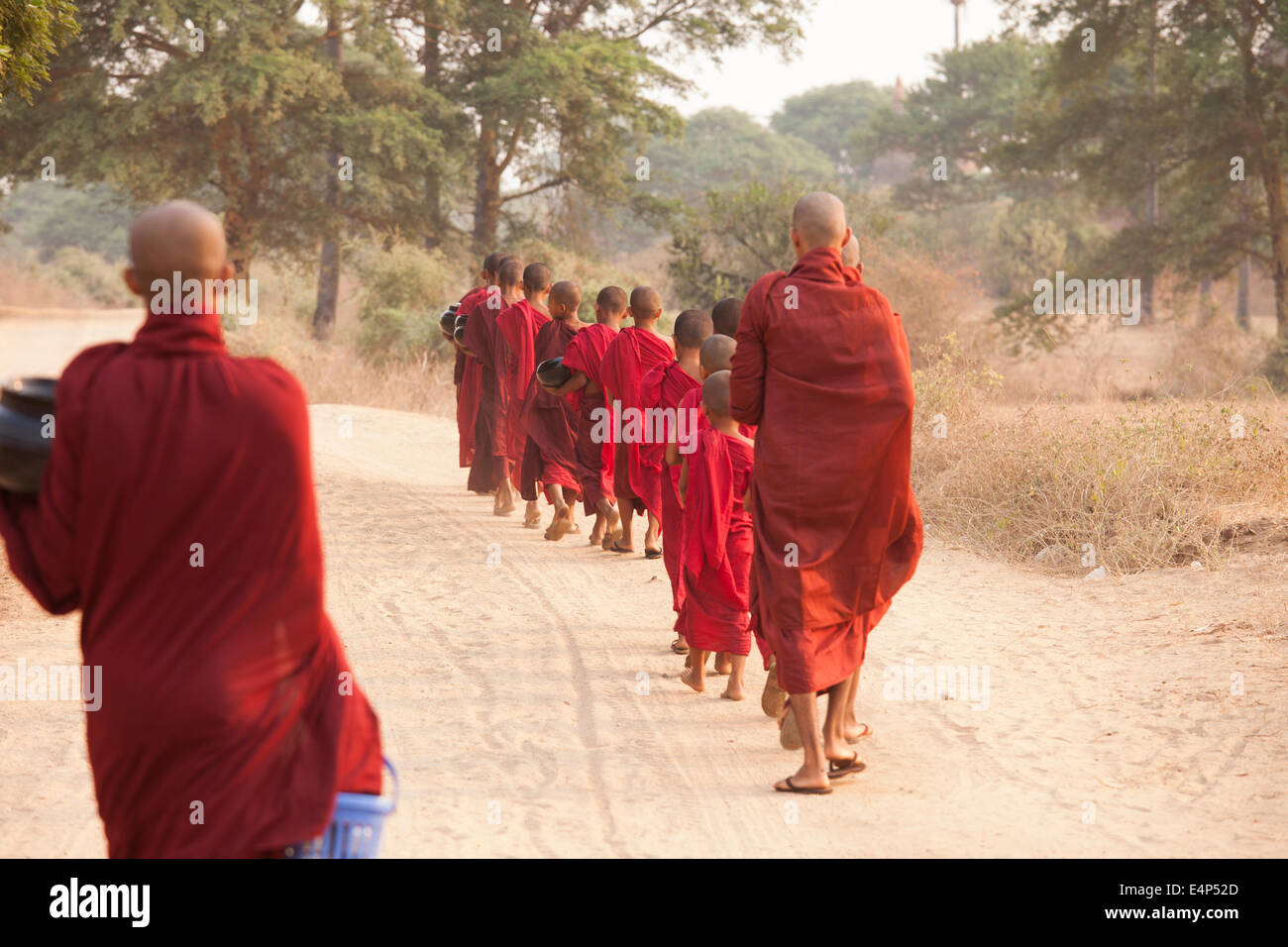 Mönche zu Fuß Einzeldatei-zu Jahresbeginn ein Almosen runden, in denen sie gesammelt werden gespendet für einheimische Essen. Stockfoto