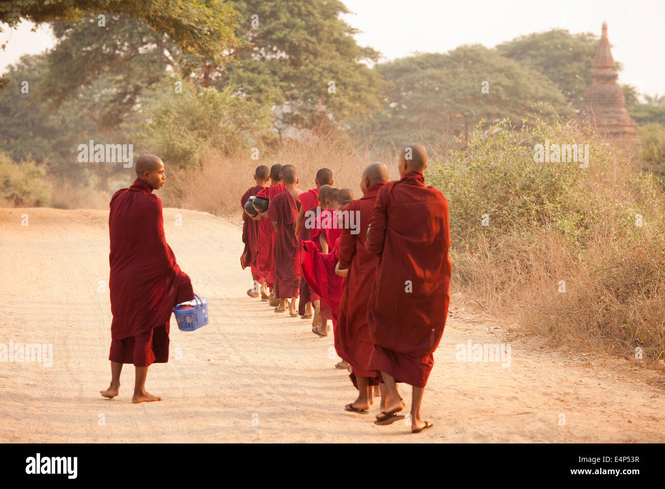 Mönche in ein kleines Kloster in Bagan, Myanmar, beginnt eine Prozession, ein Almosen Runden in denen sie gespendete Lebensmittel erhalten. Stockfoto