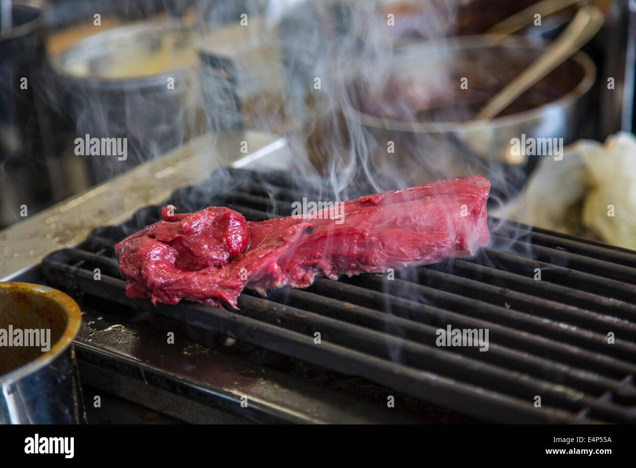 Restaurantküche, wird ein Rindersteak auf dem Grill vorbereitet, Stockfoto