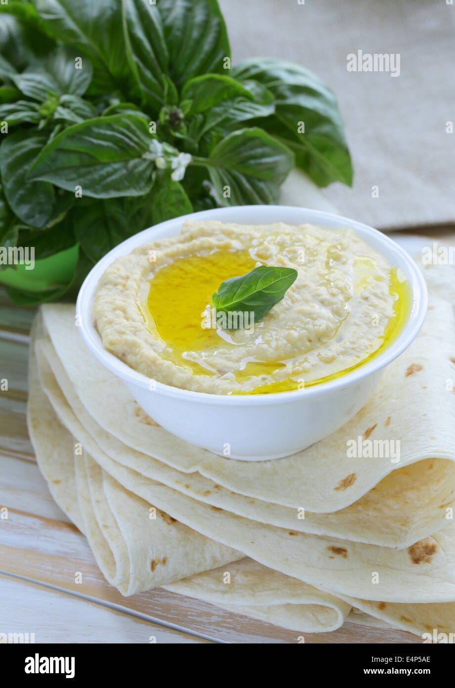 traditionelles Hummus-Dip von Kichererbsen mit Fladenbrot auf einem Holztisch Stockfoto