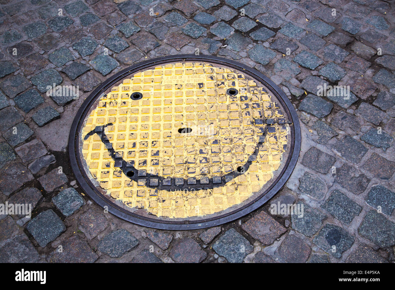 Schachtdeckel mit einem Smiley-Gesicht gemalt, Stockfoto
