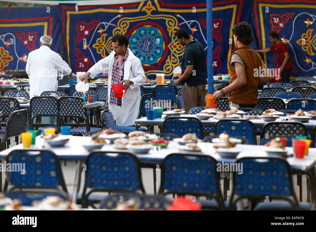 Kairo, Ägypten. 15. Juli 2014. Mitarbeiter an eine Wohltätigkeitsorganisation bereiten Mahlzeiten für ein Charity-Bankett in Kairo, Ägypten, 15. Juli 2014. Nächstenliebe Bankette oder ma'idat al-Rahman, eine langjährige Tradition der Ramadan in Ägypten, vertreten durch die wohlhabende Gönner ihre weniger wohlhabenden Glaubensgenossen zu den Mahlzeiten bieten, das Fasten zu brechen. © Cui Xinyu/Xinhua/Alamy Live-Nachrichten Stockfoto