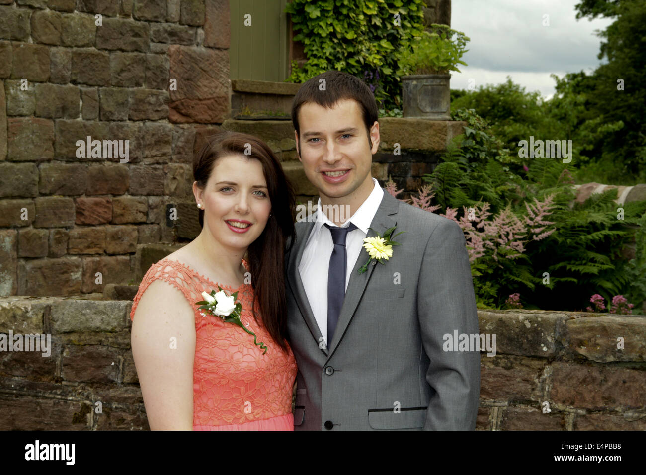 Junges Paar auf einer Hochzeit lächelnd in die Kamera Stockfoto
