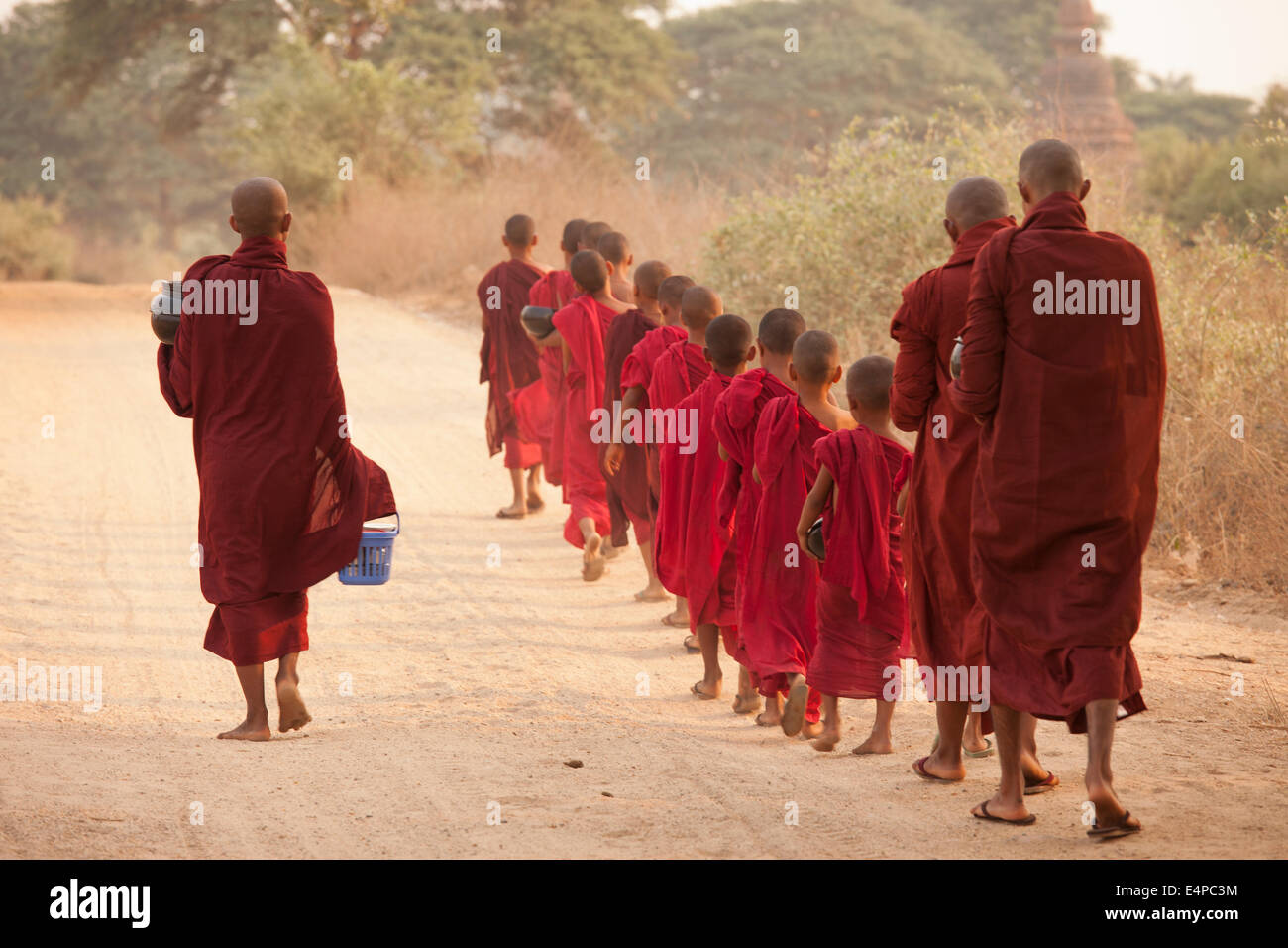 Mönche in ein kleines Kloster in Bagan, Myanmar, beginnt eine Prozession, ein Almosen Runden in denen sie gespendete Lebensmittel erhalten. Stockfoto