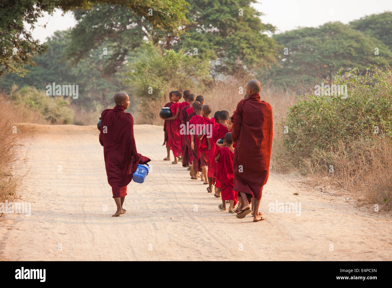 Mönche in ein kleines Kloster in Bagan, Myanmar, beginnt eine Prozession, ein Almosen Runden in denen sie gespendete Lebensmittel erhalten. Stockfoto