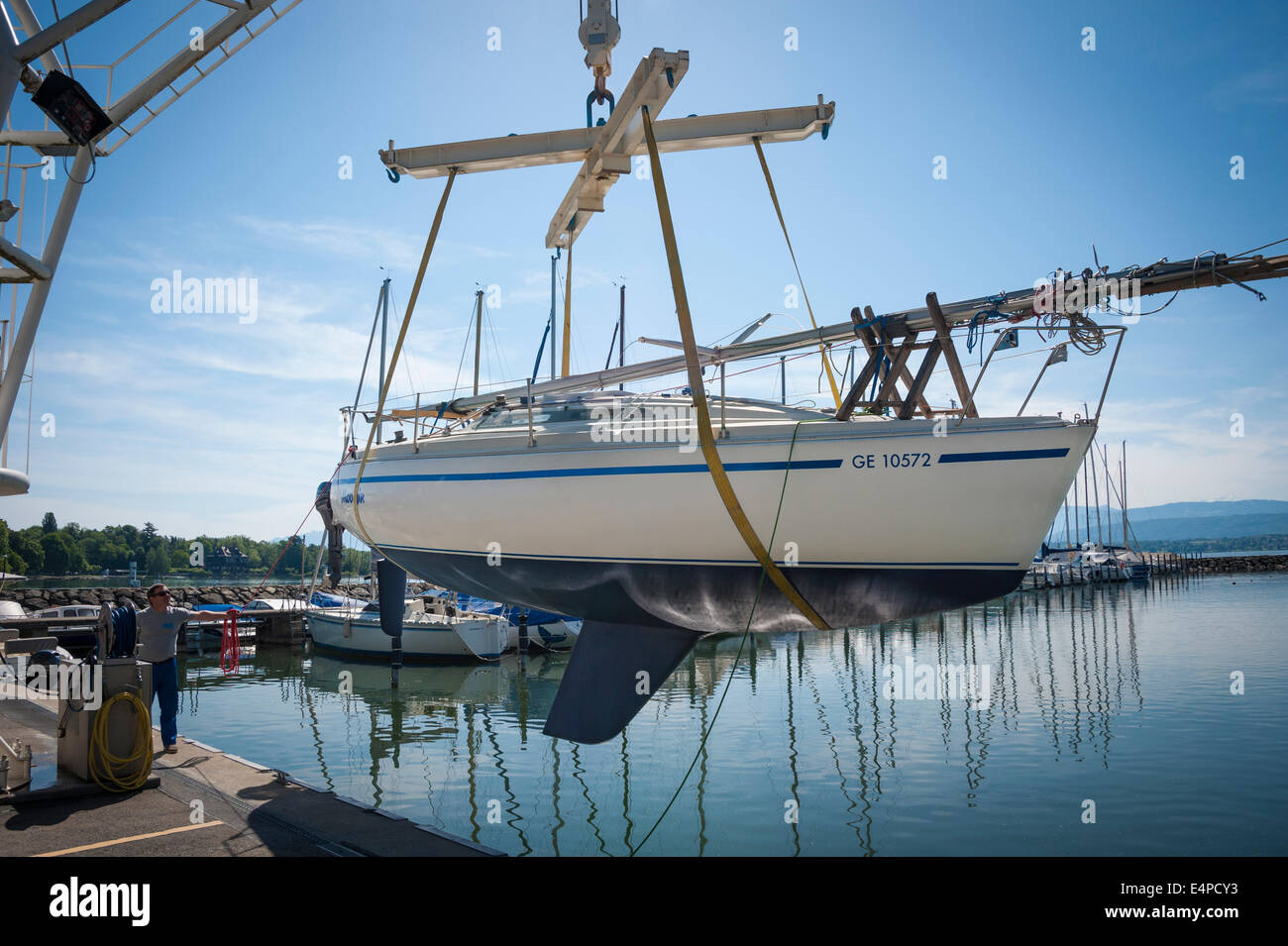 Eine Segelyacht mit einem Kran in einem Hafen am Lac Leman (Genfer See) ins Wasser gehoben Stockfoto