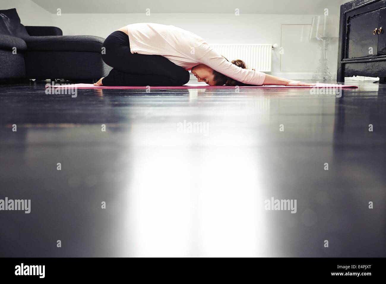 Seitenansicht des Fit junge Dame praktizieren Yoga zu Hause. Gesunde Frau im Wohnzimmer ausüben. Stockfoto