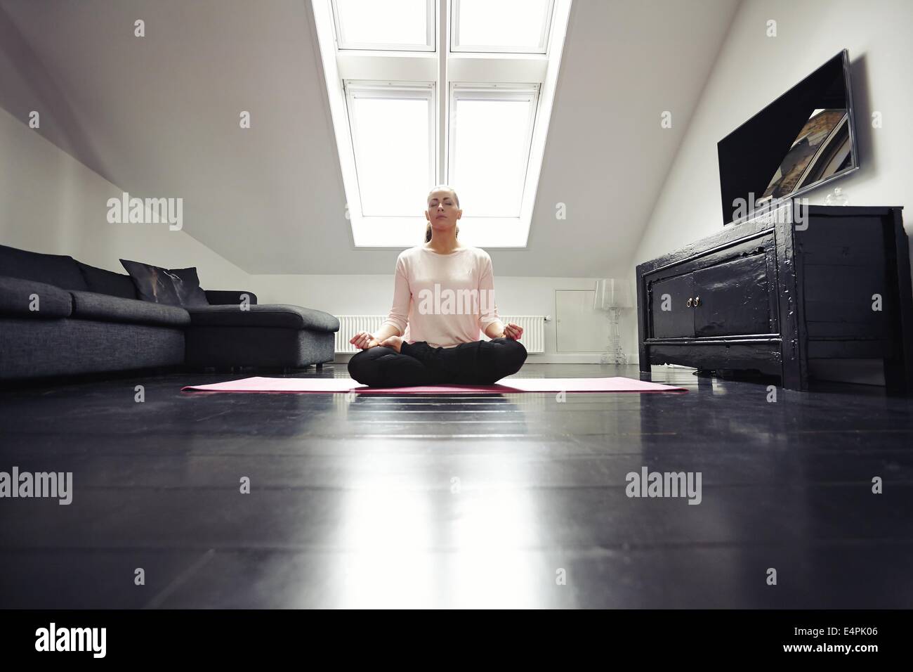 Porträt der gesunde junge Frau, die Ausübung von Yoga im Wohnzimmer. Fitness-Weibchen mit Yoga Meditation zu Hause entspannen. Stockfoto