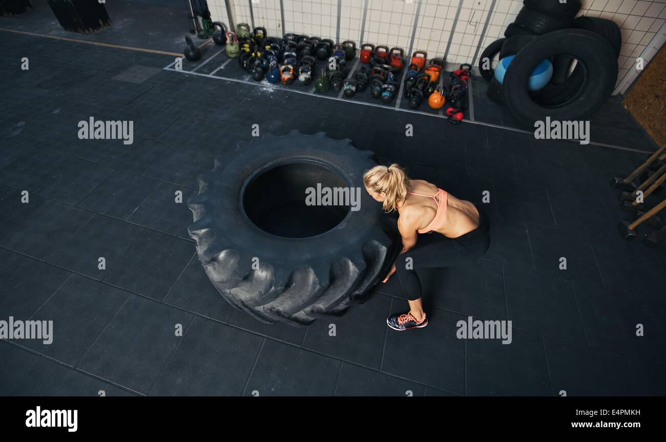Draufsicht der jungen weiblichen spiegeln schweren Reifen. Frau Crossfit Training im Fitness-Studio zu tun. Stockfoto