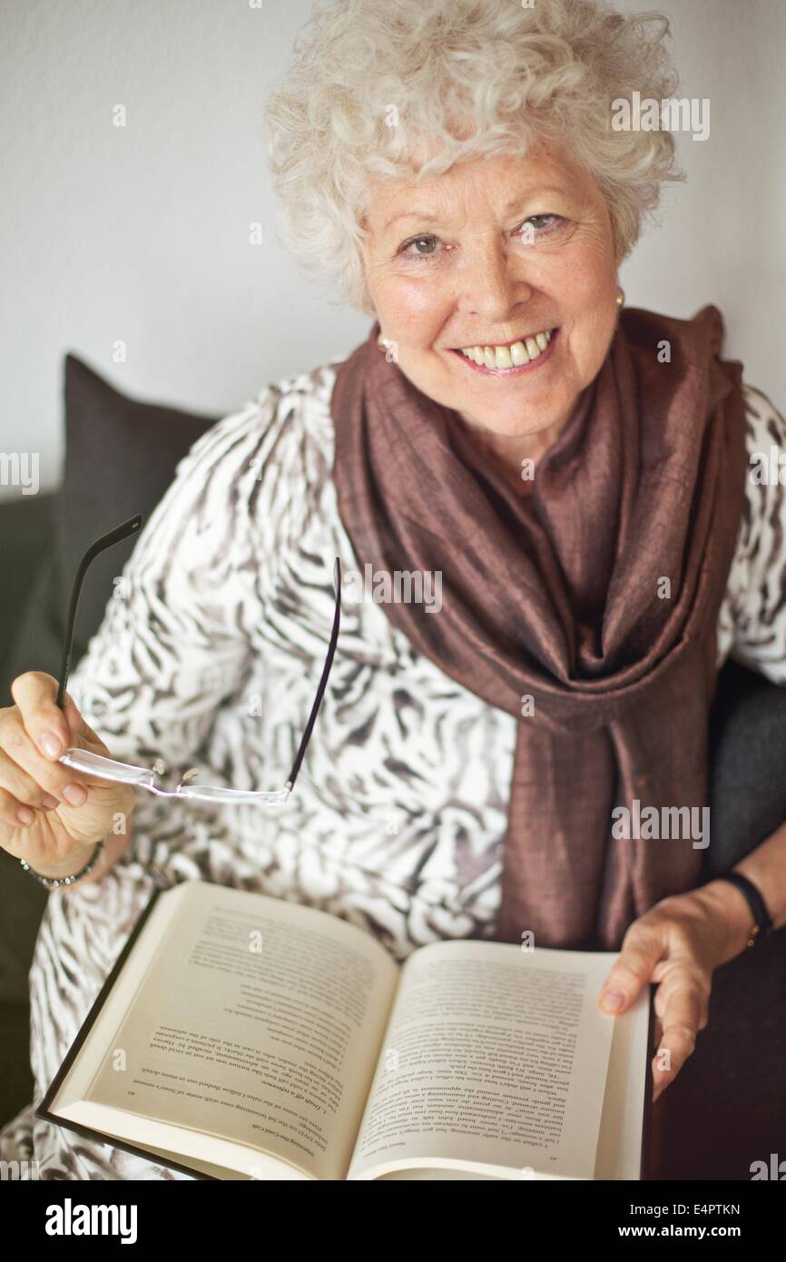 Fröhliche Reife Dame im Hause genießen ein gutes Buch Stockfoto