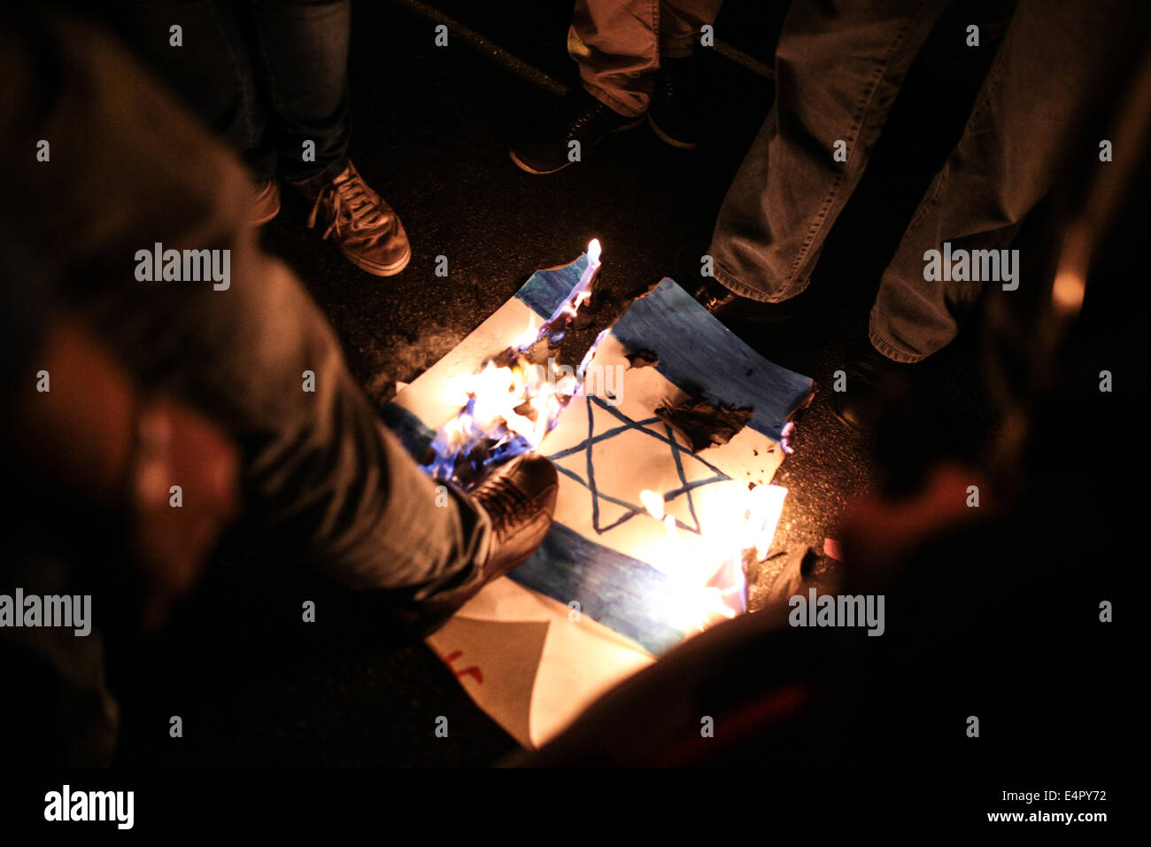 Sao Paulo, Brasilien. 15. Juli 2014. Die Anhänger der palästinensischen Sache treten während ein Kerzenlicht-Mahnwache in Unterstützung für das palästinensische Volk eine Israel-Flagge in der Mitte einer Straße in Sao Paulo, Brasilien. Die Vigil wurde organisiert von den Palästinensern und anderen Unterstützern mit Wohnsitz in Brasilien die Israelis kontinuierliche Stampfen im Gaza-Streifen zu verurteilen. Bildnachweis: Tiago Mazza Chiaravalloti/Pacific Press/Alamy Live-Nachrichten Stockfoto