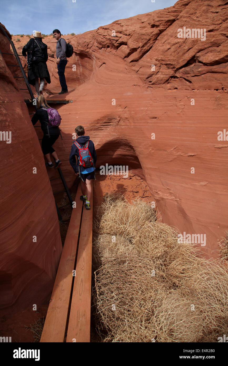 Tourist, Tumbleweed und Leiter am Eintrag Rattlesnake Canyon in der Nähe von Page, Navajo Nation, Arizona, USA Stockfoto