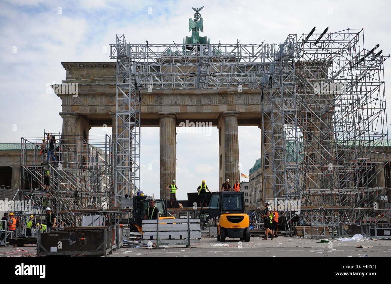 Arbeiter zerlegen die Bühne auf der "Straße des 17. Juni. Juni "vor dem Brandenburger Tor in Berlin, Deutschland, 16. Juli 2014. Für die Dauer der 2014 World Cup, die so genannte "Fan-Meile" war der zentrale Standort für die öffentlichen Fan-feste, die während der 2014 abgehalten wurden Spiele World Cup. Foto: Britta Pedersen/dpa Stockfoto