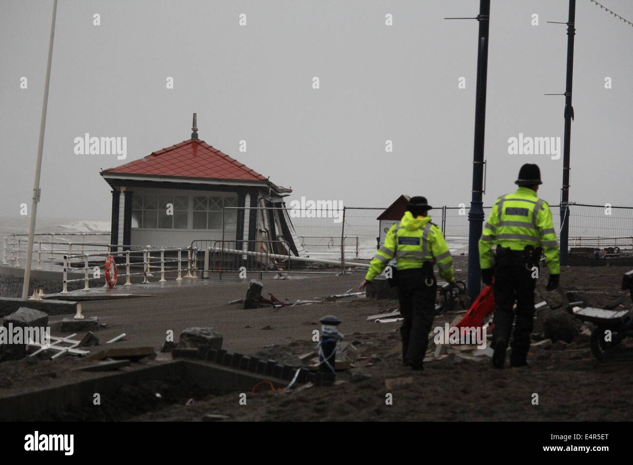 Aberystwyth Polizeistreife die Promenade nach dem großen Sturm Besichtigung Schadens um öffentliche Tierheim zum Scheitern verurteilt. Stockfoto