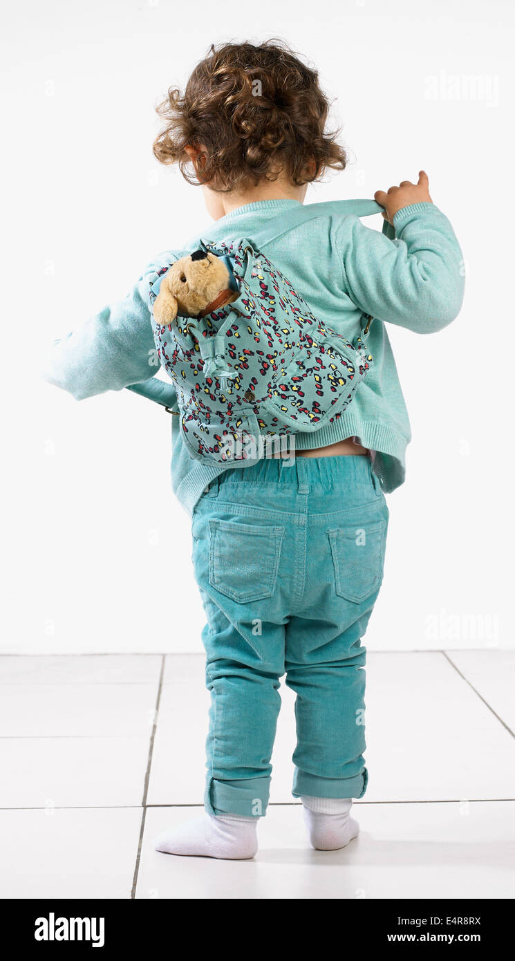 Junges Mädchen (2 Jahre) ihren Rucksack einstellen Stockfoto