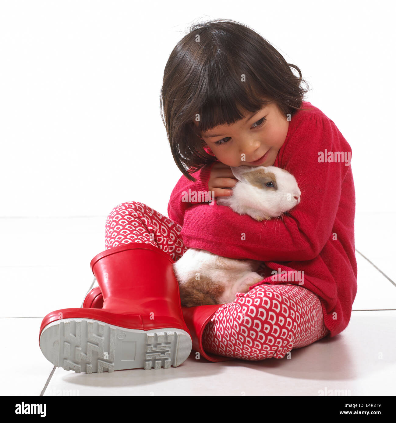 Kleines Mädchen (2 Jahre) umarmt Kaninchen Stockfoto