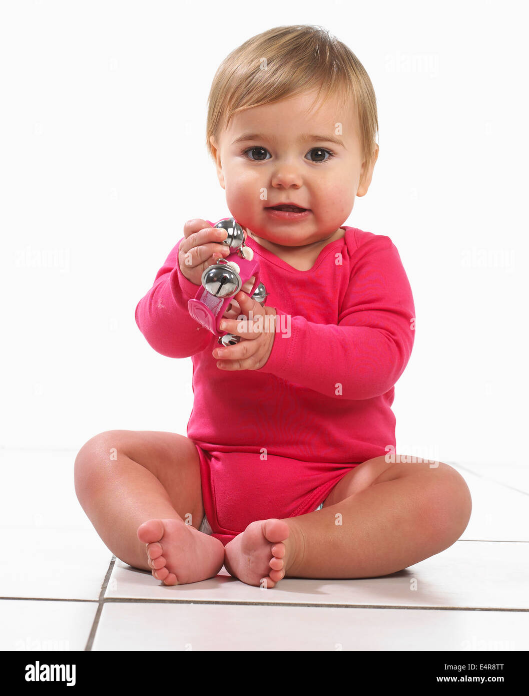 Babymädchen (12 Monate) halten Glocken Stockfoto