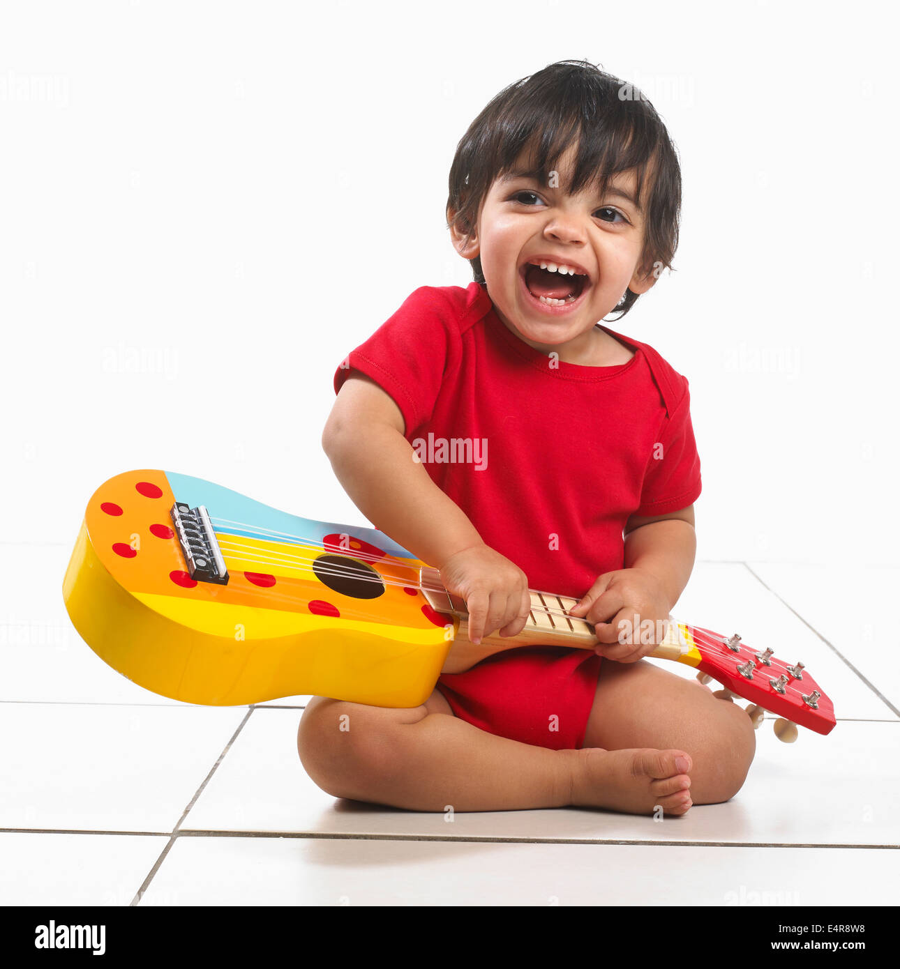 Kleiner Junge (16 Monate) mit bunten Gitarre Stockfoto