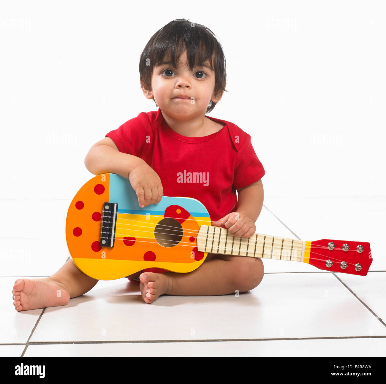Kleiner Junge (16 Monate) mit bunten Gitarre Stockfoto