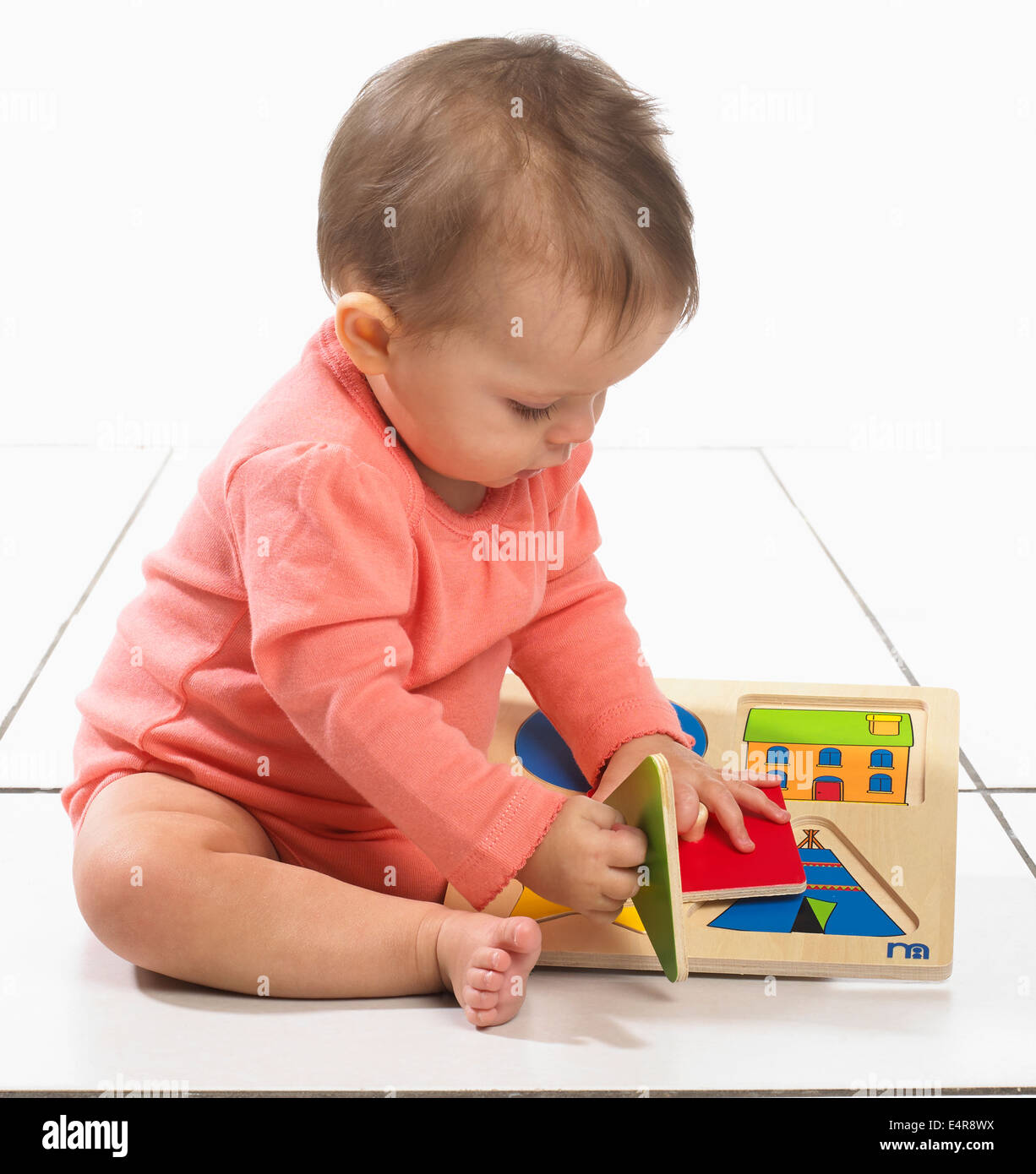 Baby Girl (8 Monate) mit einem Puzzle spielen Stockfoto