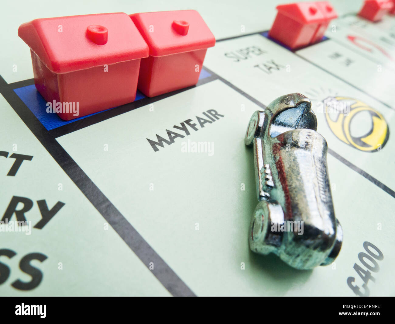 "MAYFAIR" auf das Monopoly-Brett mit dem Auto und zwei Hotels. Stockfoto