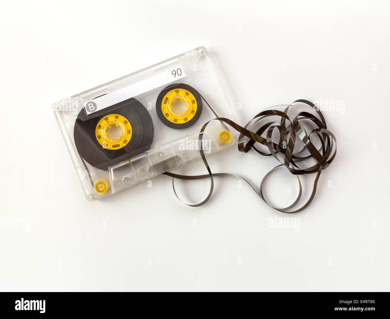 Eine einzige UN-branded kompakte Audiokassette mit leere Beschriftung und eine kleine Menge der verworrenen Band aus dem Gehäuse Stockfoto