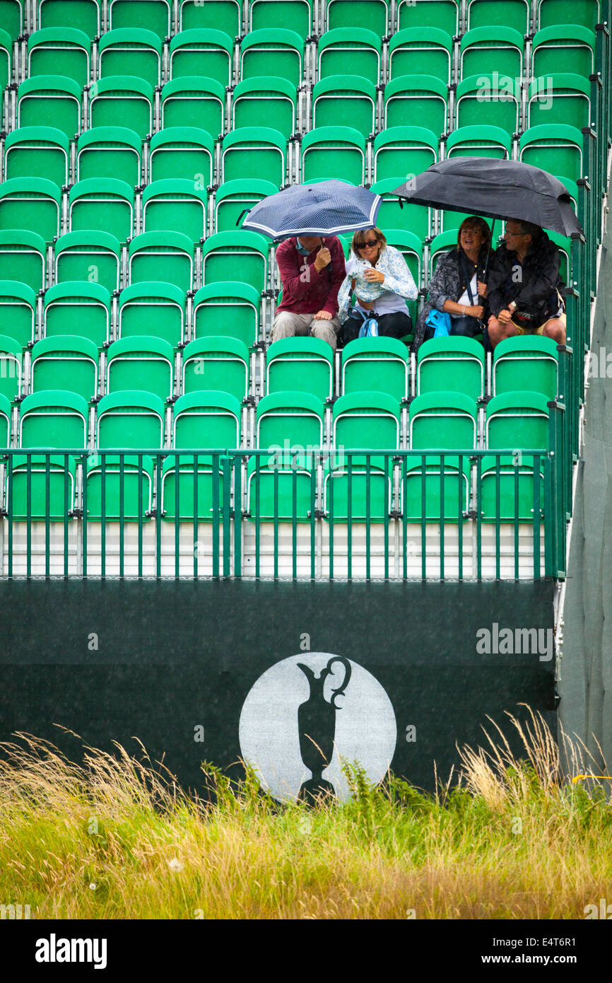 Zuschauer sitzen unter Sonnenschirmen auf einem der British Open Golf am Golfplatz Royal Liverpool für die British Open 2014 wie es regnet Stockfoto