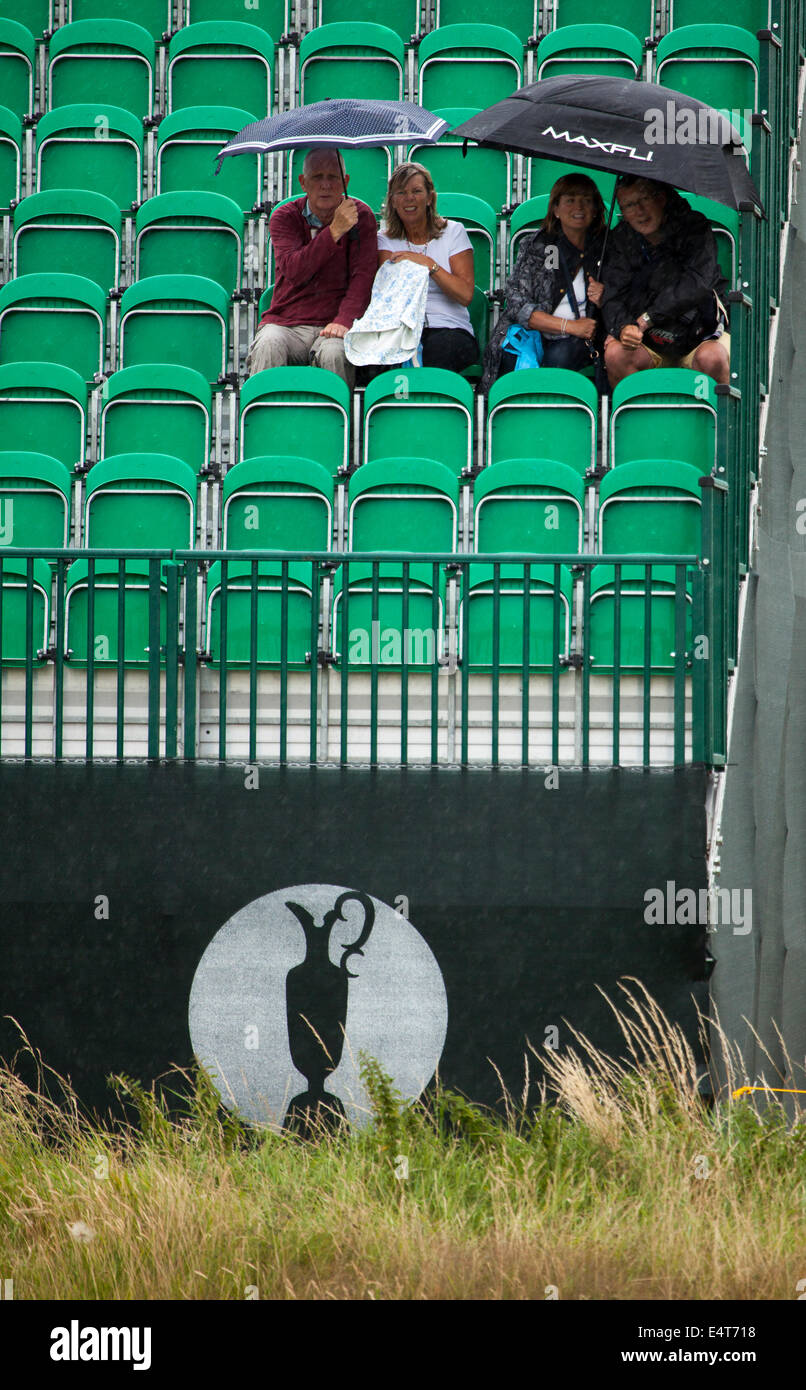 Zuschauer sitzen unter Sonnenschirmen auf einem der British Open Golf am Golfplatz Royal Liverpool für die British Open 2014 wie es regnet Stockfoto