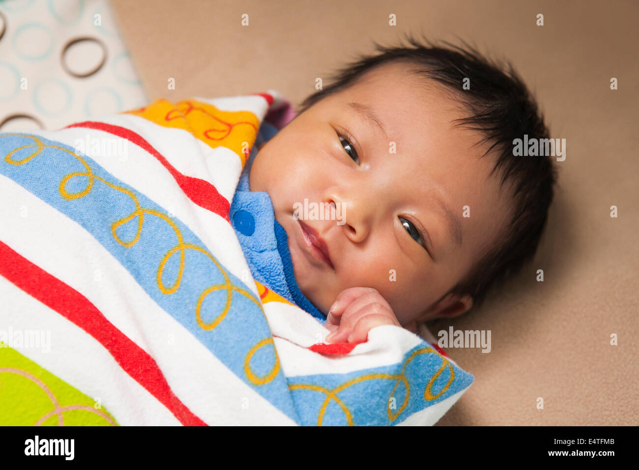 Close-up Portrait von zwei Wochen alten, Neugeborenen asiatisches Babymädchen, in bunte Windeln Decke gehüllt, Studio gedreht Stockfoto