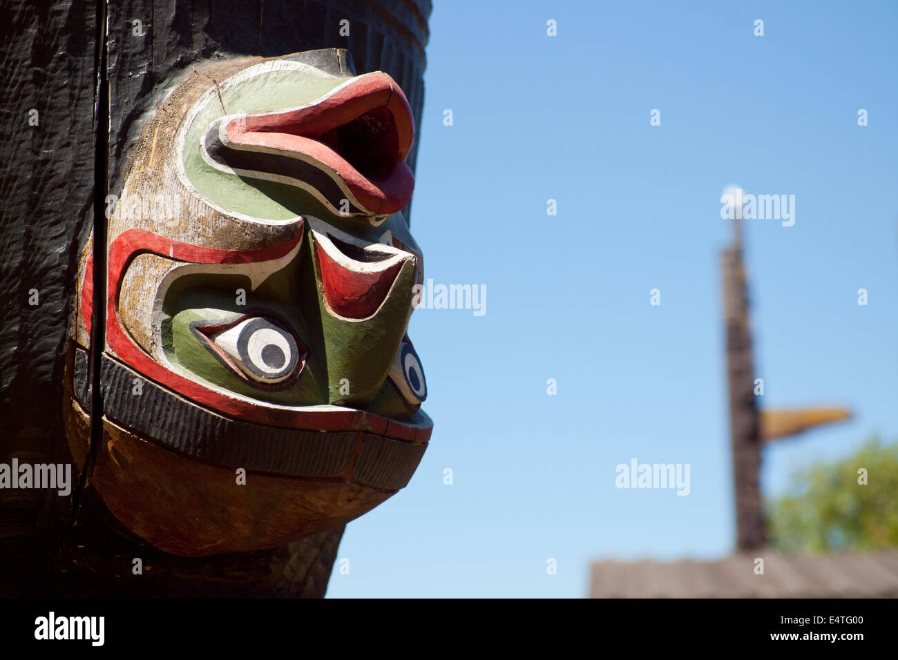 Eine Nahaufnahme eines umgekehrten Totem Schnitzen auf einem Kwakwa̱ka̱'Wakw Ehren Totempfahl in Thunderbird Park, Victoria, Kanada. Stockfoto