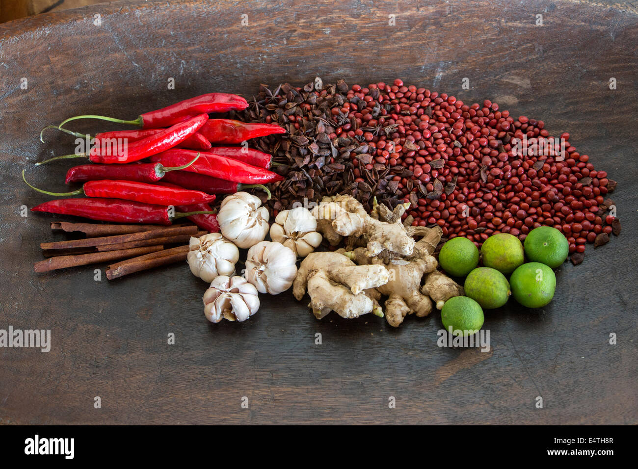 Balinesische Gewürze: Knoblauch, Ingwer, Chilis, Zimt, Limes, Sternanis sowie Saga (rote Perle Baum)-Samen für die Dekoration. Stockfoto