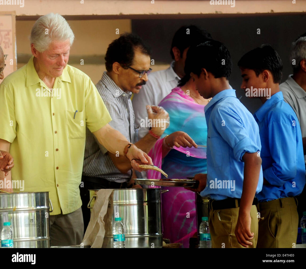 Jaipur, Indien. 16. Juli 2014. Ehemaliger US-Präsident Bill Clinton (1. L) serviert Essen für Studenten in Jaipur, Indien, 16. Juli 2014. Ehemaliger US-Präsident Bill Clinton kam Dienstag in Jaipur, der Hauptstadt des indischen Bundesstaat Rajasthan, um einen Einblick in eine NGO-Run Mittagessen Plan für Schülerinnen und Schüler haben. Bildnachweis: Stringer/Xinhua/Alamy Live-Nachrichten Stockfoto