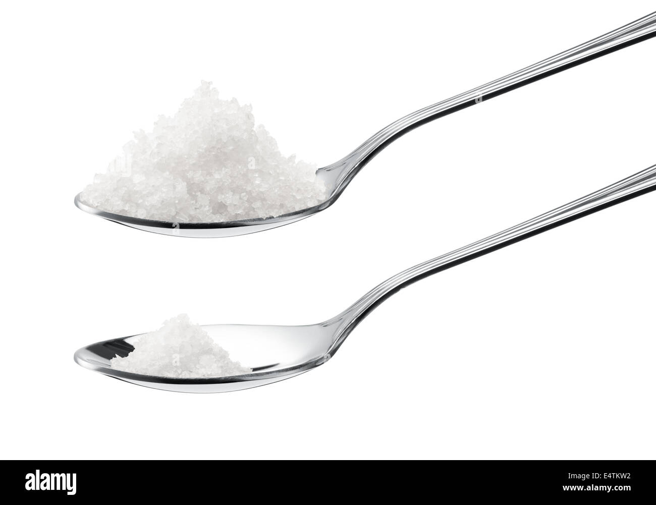 weniger Salz im Vergleich zu mehr auf Teelöffel, gesunde Ernährung Konzept Stockfoto