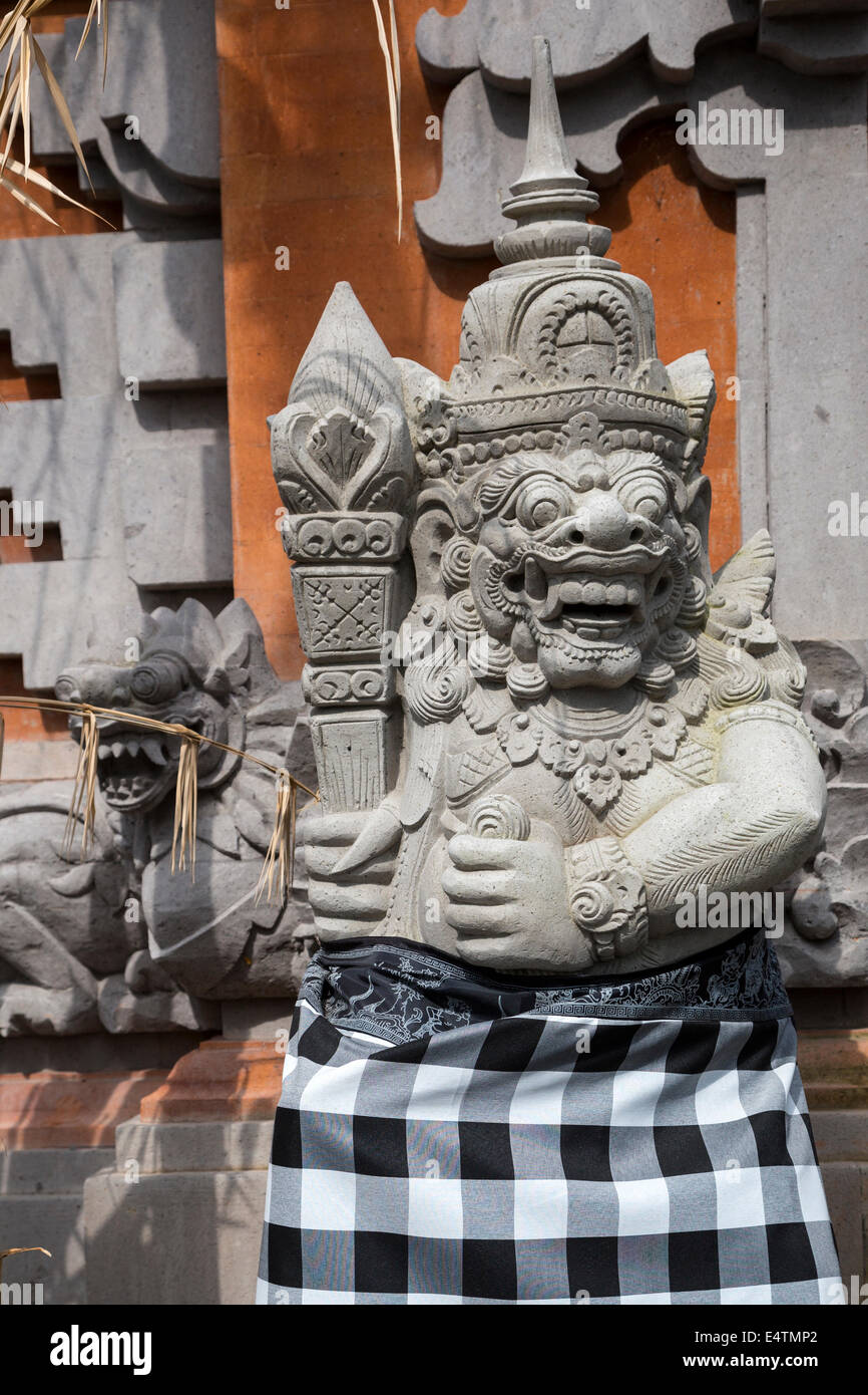 Bali, Indonesien.  Hinduistischer Tempelwächter eingehülltes Poleng Tuch, als Symbol für die dualistische Natur des Universums.  Pura Dalem Stockfoto