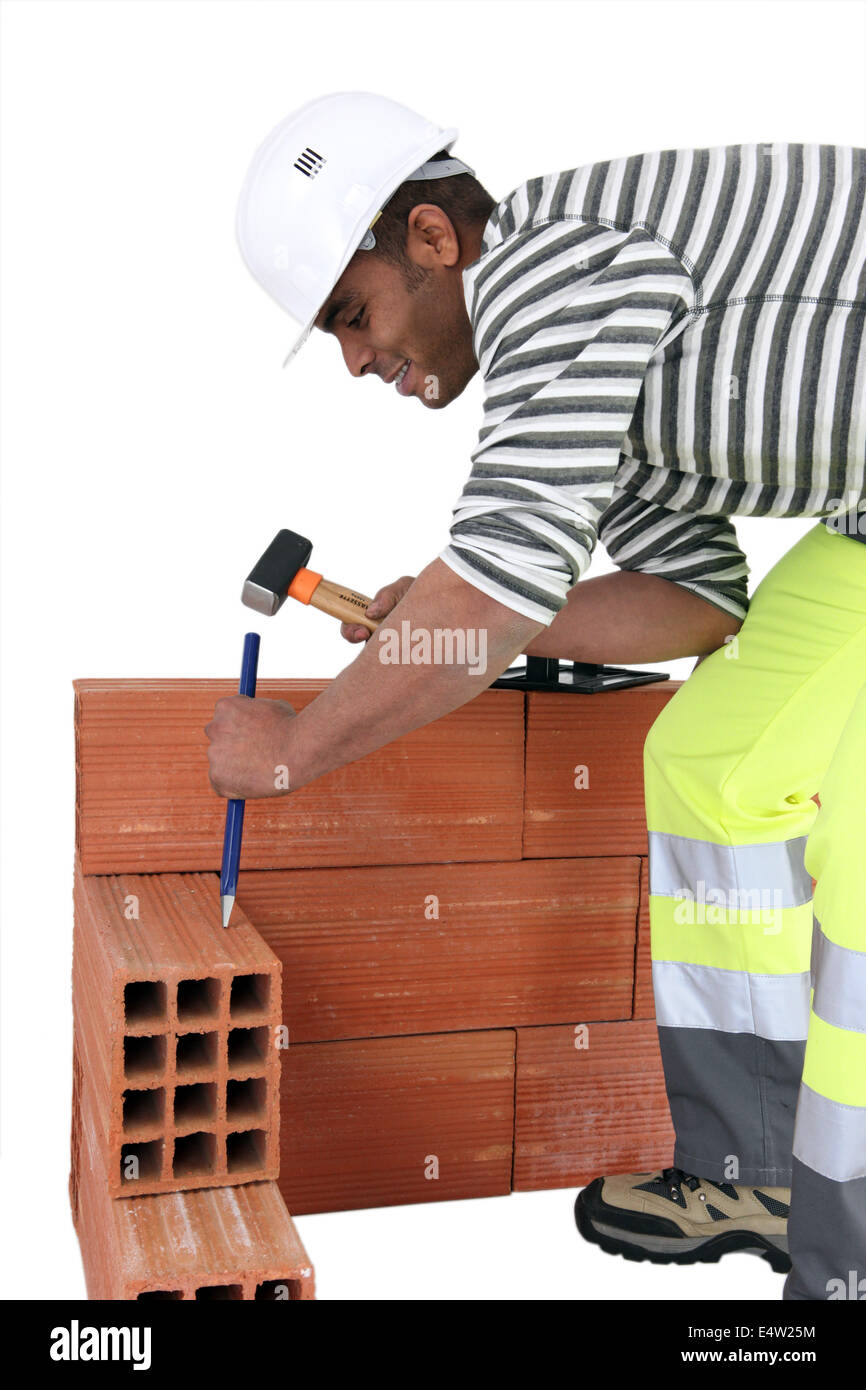 Maurer mit Hammer und Meißel Stockfoto