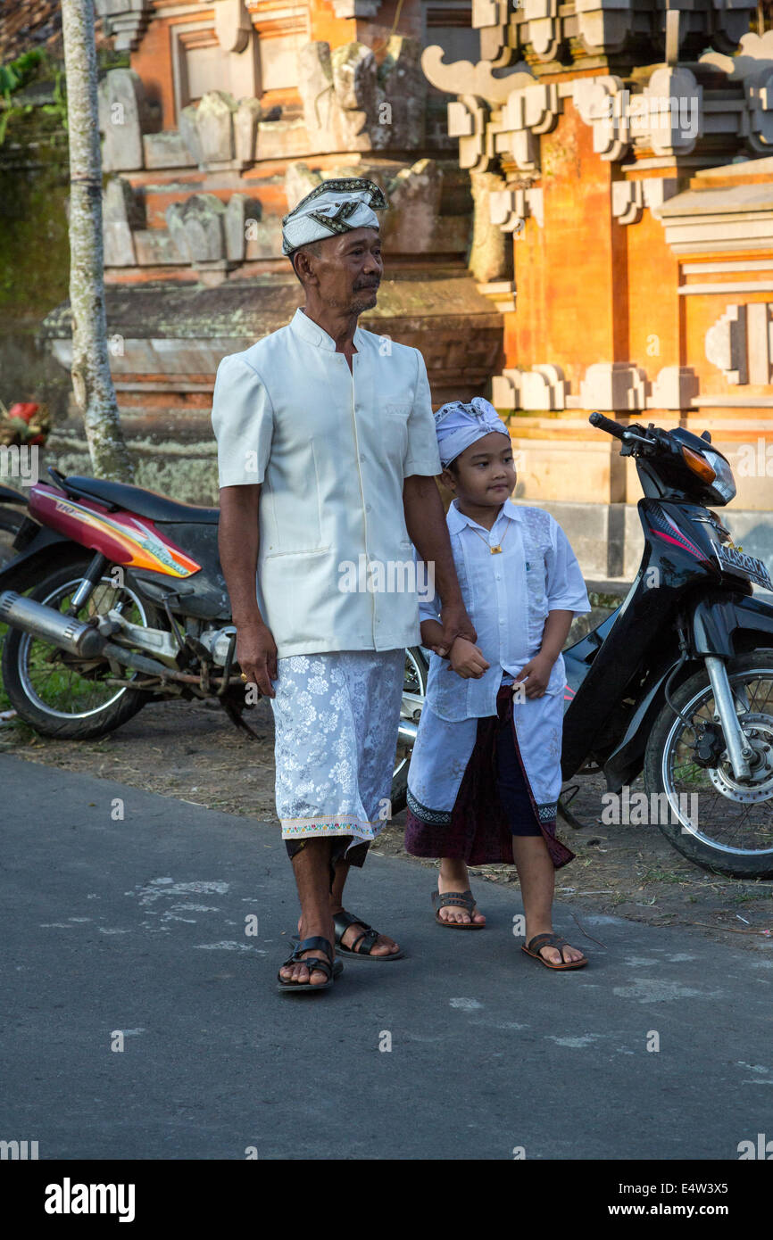 Bali, Indonesien.  Vater und Sohn in den Tempel gehen.  Beide tragen die Udeng, die traditionelle balinesische männlichen Kopf Tuch. Stockfoto