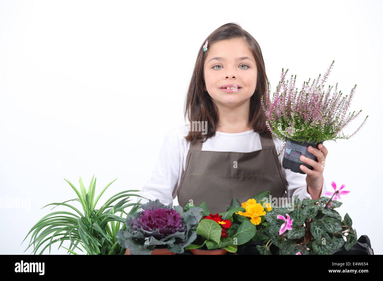 Ein kleines Mädchen posiert mit ihren Pflanzen Stockfoto