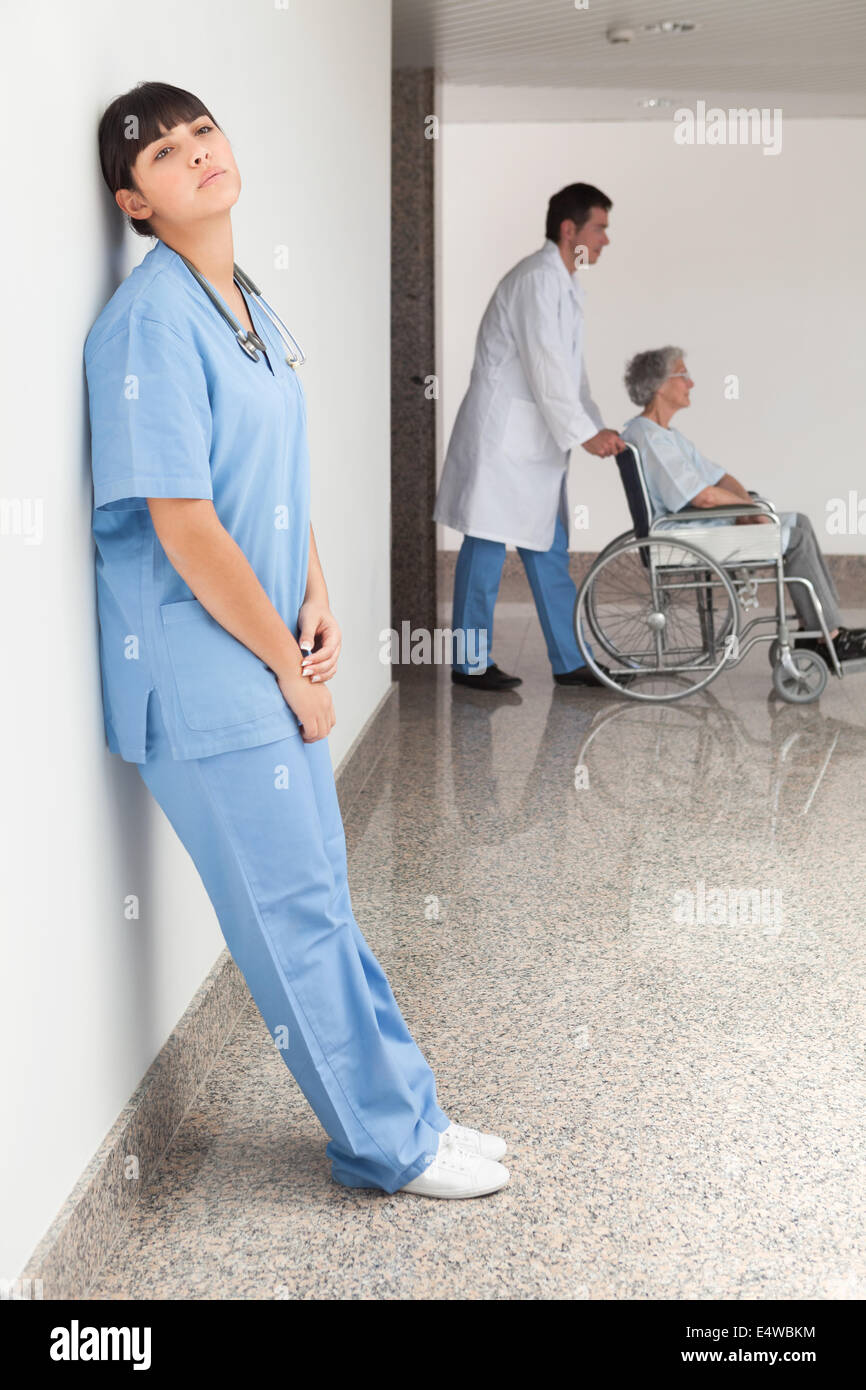 Müde Krankenschwester Wand gelehnt Stockfoto