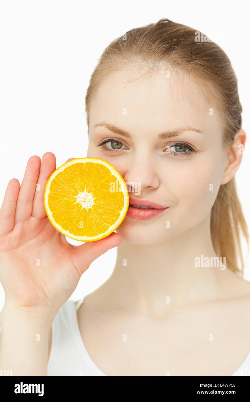 Frau, indem eine Orange auf den Lippen Stockfoto