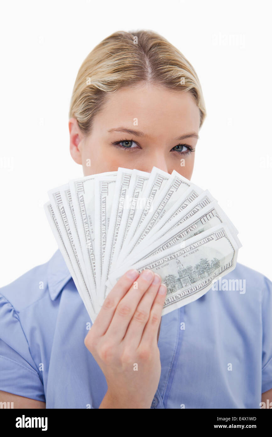 Frau verbirgt ihr Gesicht hinter Geld Stockfoto