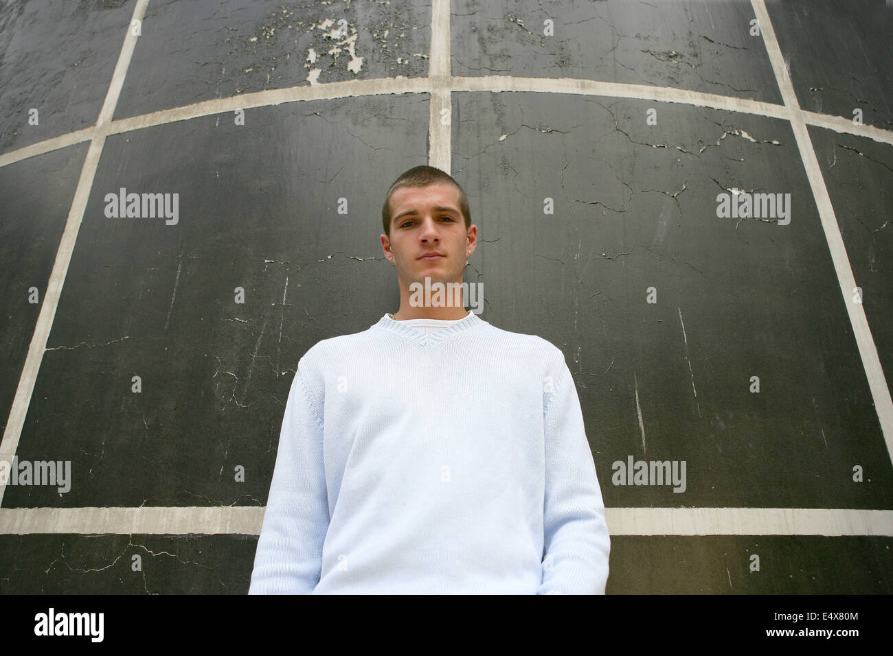 Männlichen Teenager Stand gegen die Wand Stockfoto