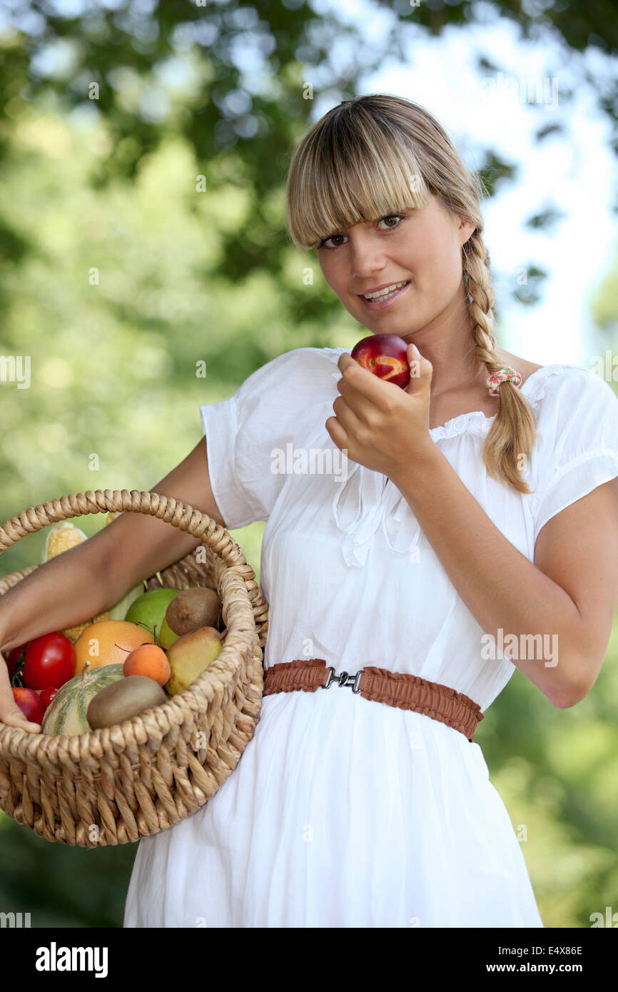 Blonde Frau mit Obstkorb Stockfoto