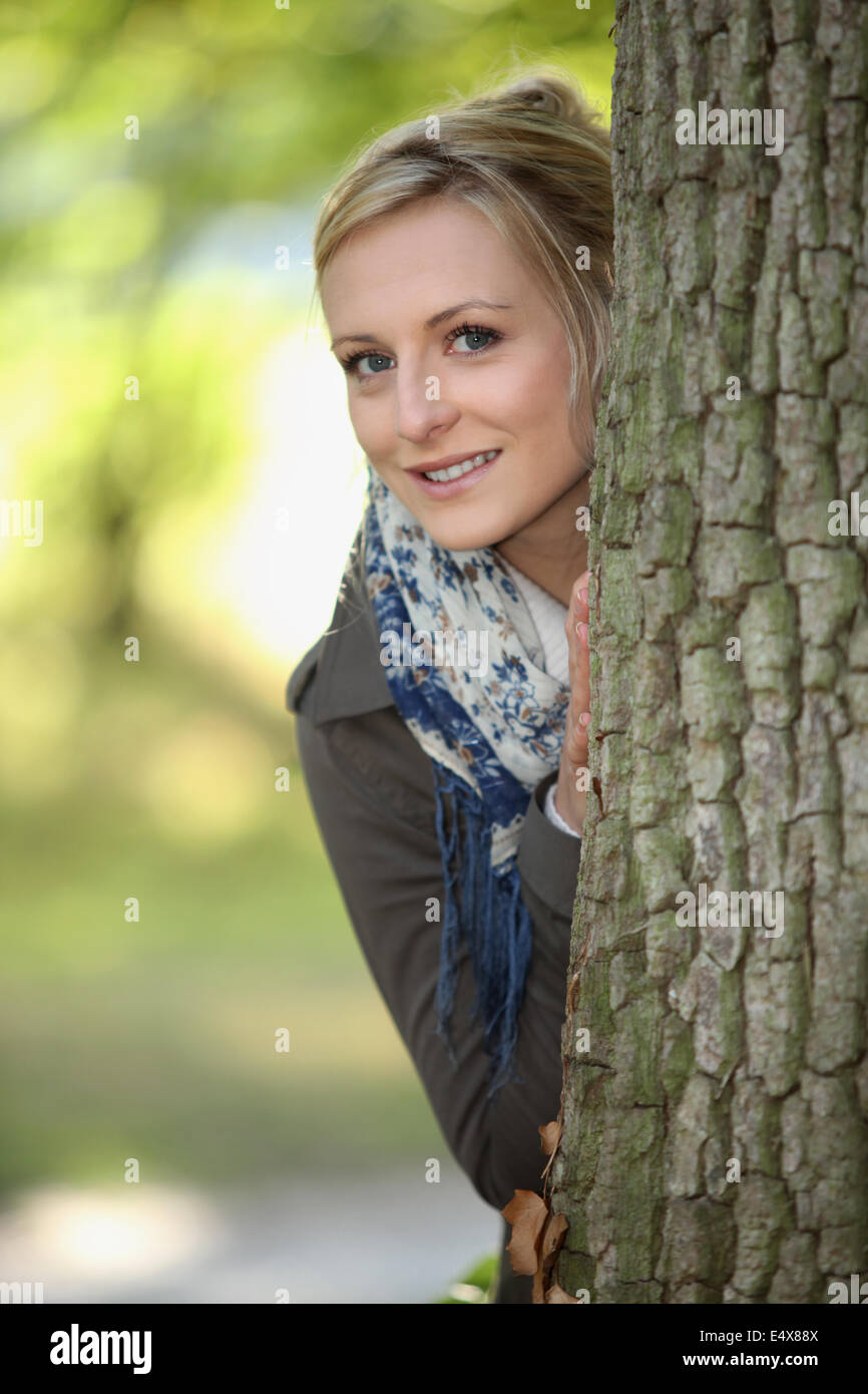 Blond, stand hinter Baum Stockfoto