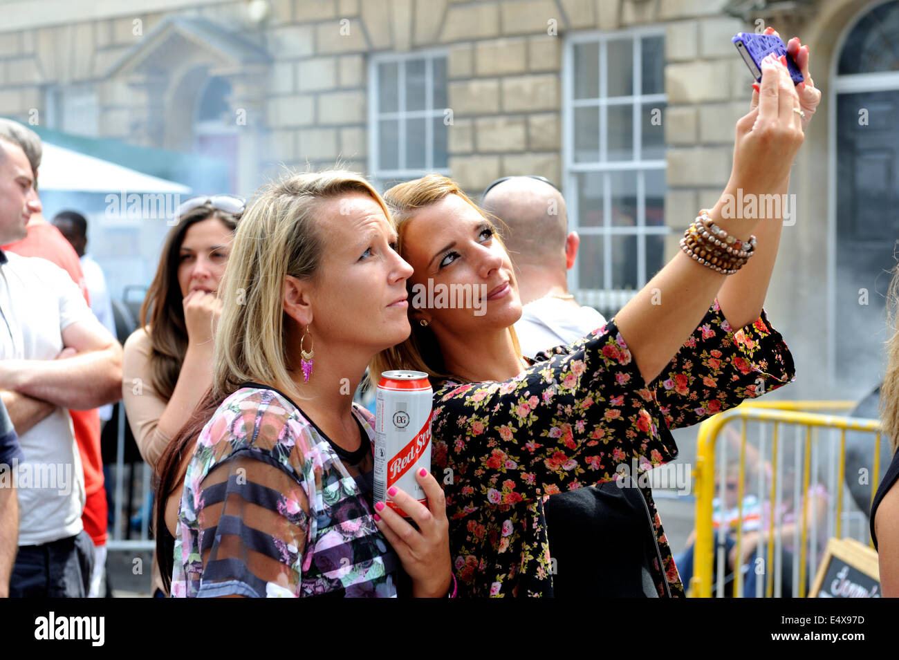 Zwei Frauen, die eine "Selfie" auf Kamera-Handy beim Straßenfest Stockfoto