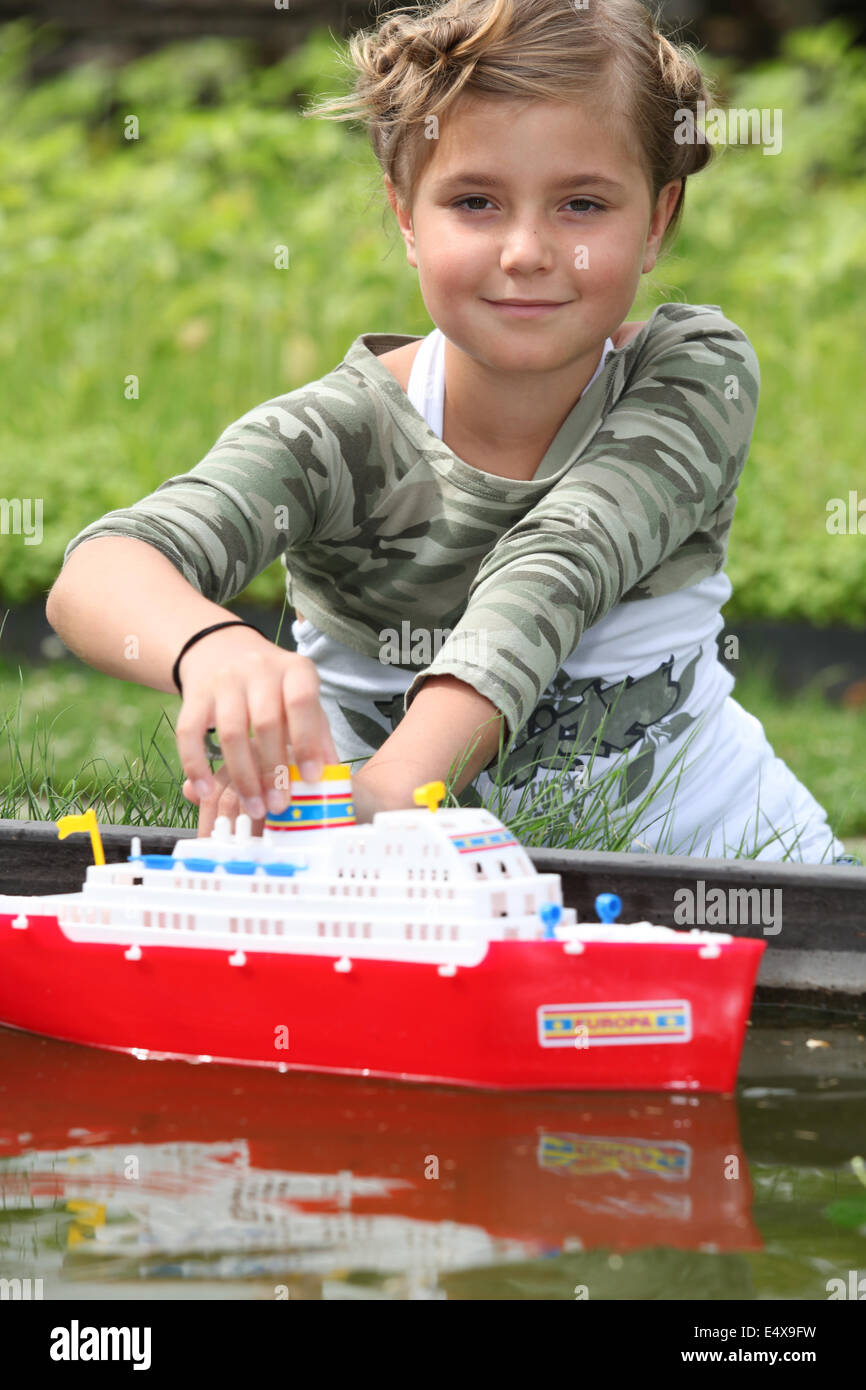 Mädchen spielen mit Boot Stockfoto