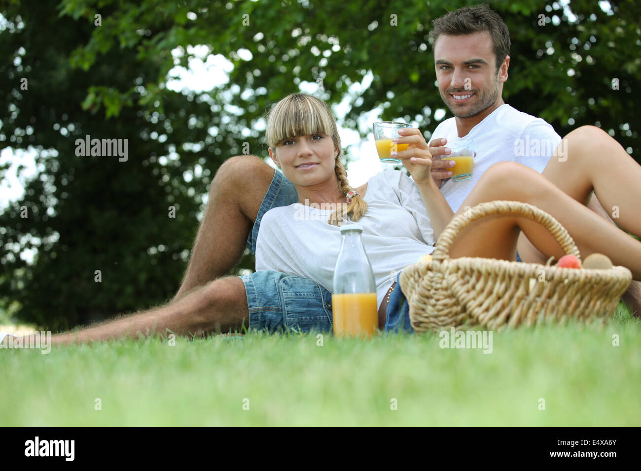 paar, Trinken von Orangensaft in einem park Stockfoto